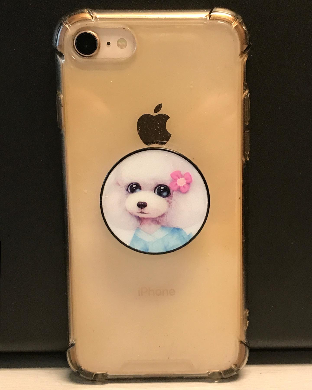 Muffy the Popsocket on a rose gold iphone in a clear plastic case